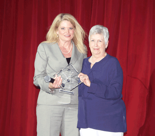 Vice President for Institutional Research and Student Affairs Dr. Lindy McCain presents a plaque to Holmes alumna Dixie Branch.