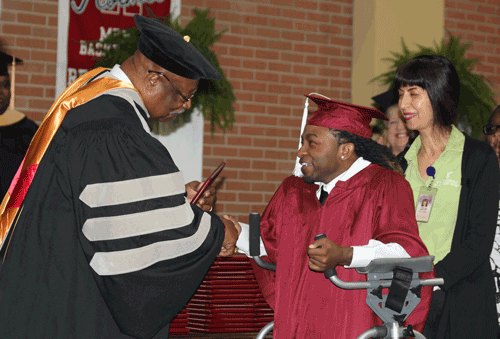 1. Pictured is Winona native Stevelyn Robinson accepting his Associate of Arts diploma from Board of Trustees member General Vann, as his physical therapist Patricia Oyarce looks on, during Holmes Community College’s 2017 Commencement Ceremony.