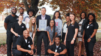 (center) Holmes Community College Ridgeland Campus Vice President Dr. Don Burnham and some of Holmes’ students pose for a photo with the Best of Mississippi plaque after being named no. 2 in the Best Two-Year College category.